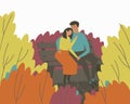 A loving couple sits on a bench in an autumn park in an embrace Royalty Free Stock Photo